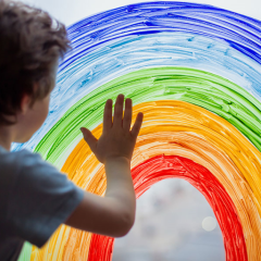 niño tocando un arco iris